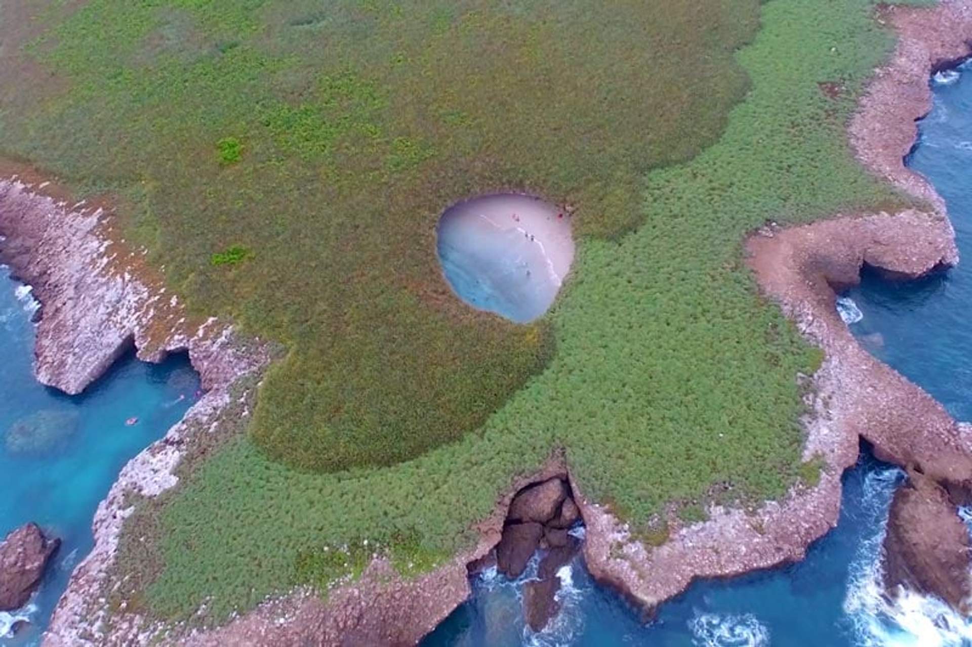Aerial view of the Hidden Beach, a secluded sandy cavern surrounded by greenery on Marieta Islands, Nayarit, Mexico.