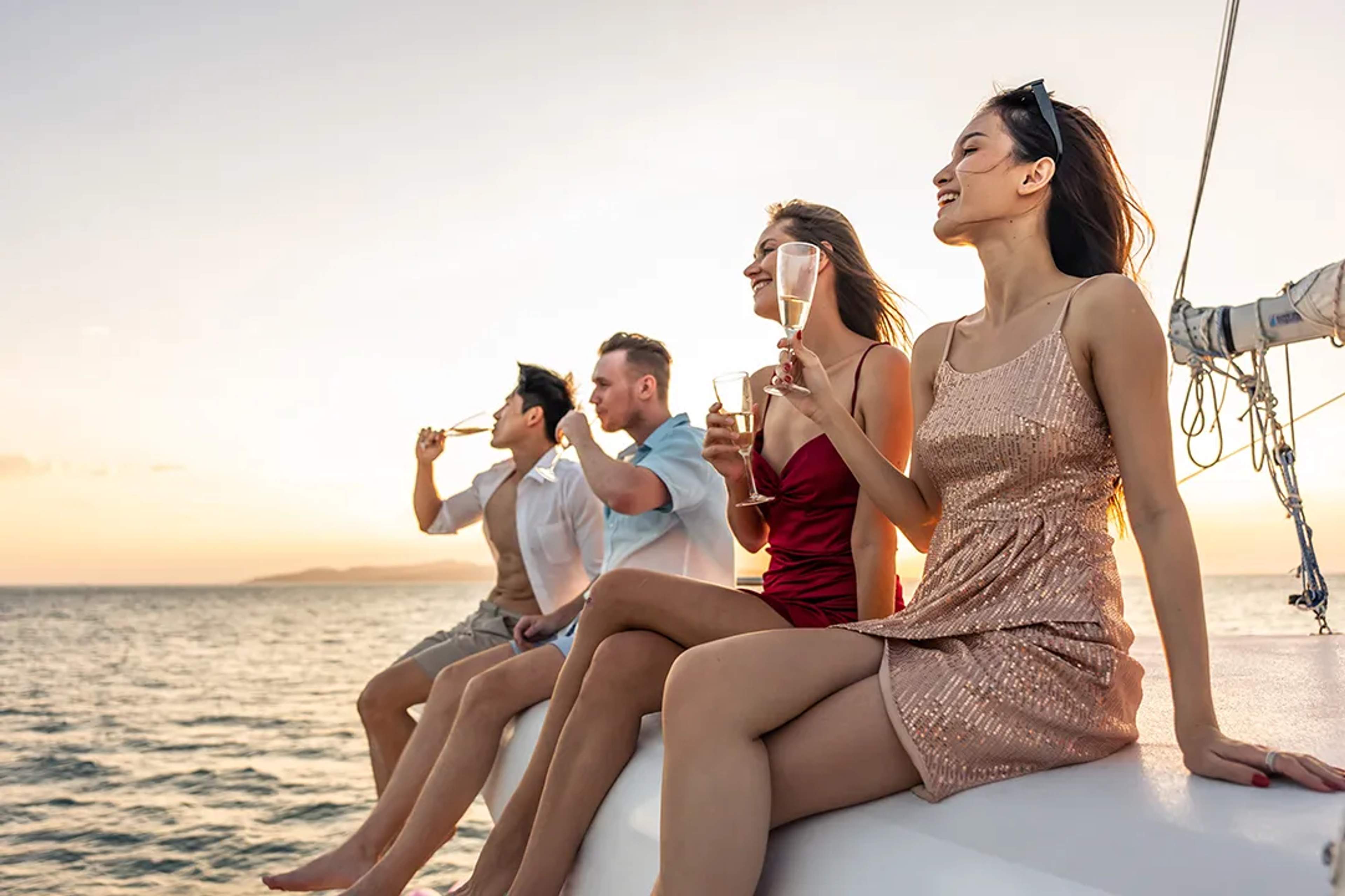 Group of friends enjoying drinks on a sailboat at sunset in Puerto Vallarta
