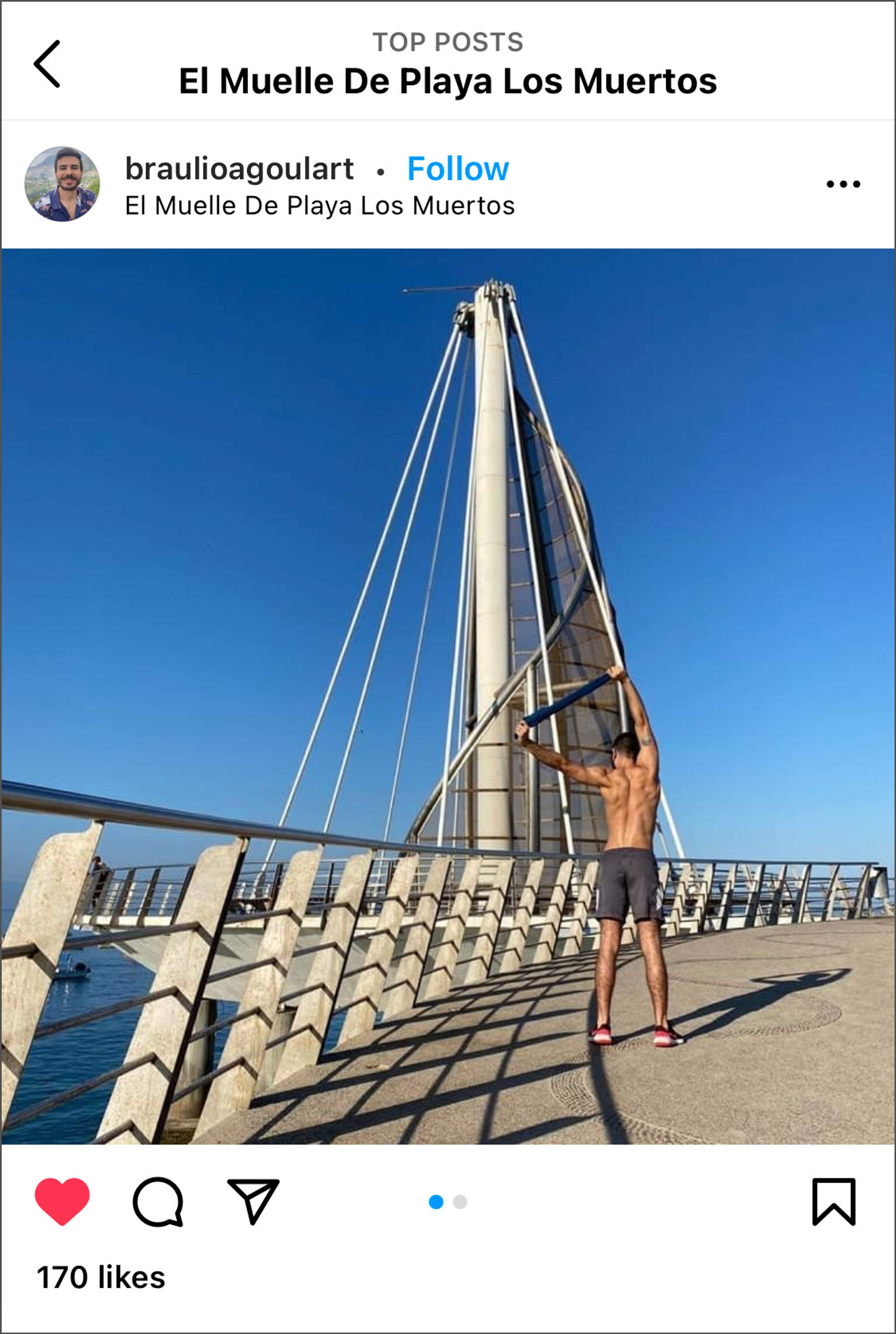 Hombre de pie en el Muelle de Playa Los Muertos en Puerto Vallarta, Jalisco, con estructura moderna de vela.