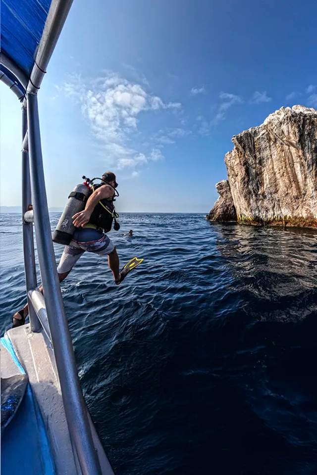 Certified Diver jumping into the water for a Scuba Diving tour at El Morro near Puerto Vallarta.
