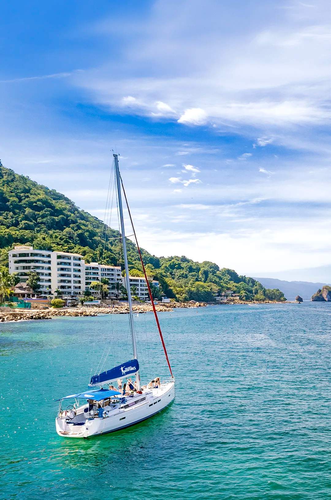 Sailboat sailing by the south shore of Puerto Vallarta on a bright day.