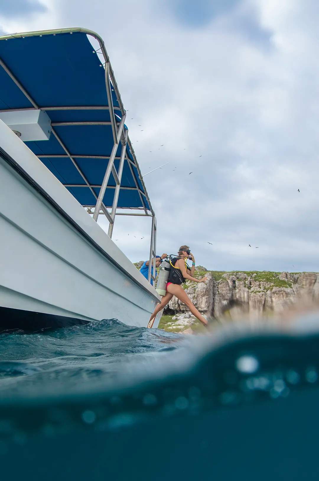Scuba diver jumping off a boat into the water near the Marietas Islands.