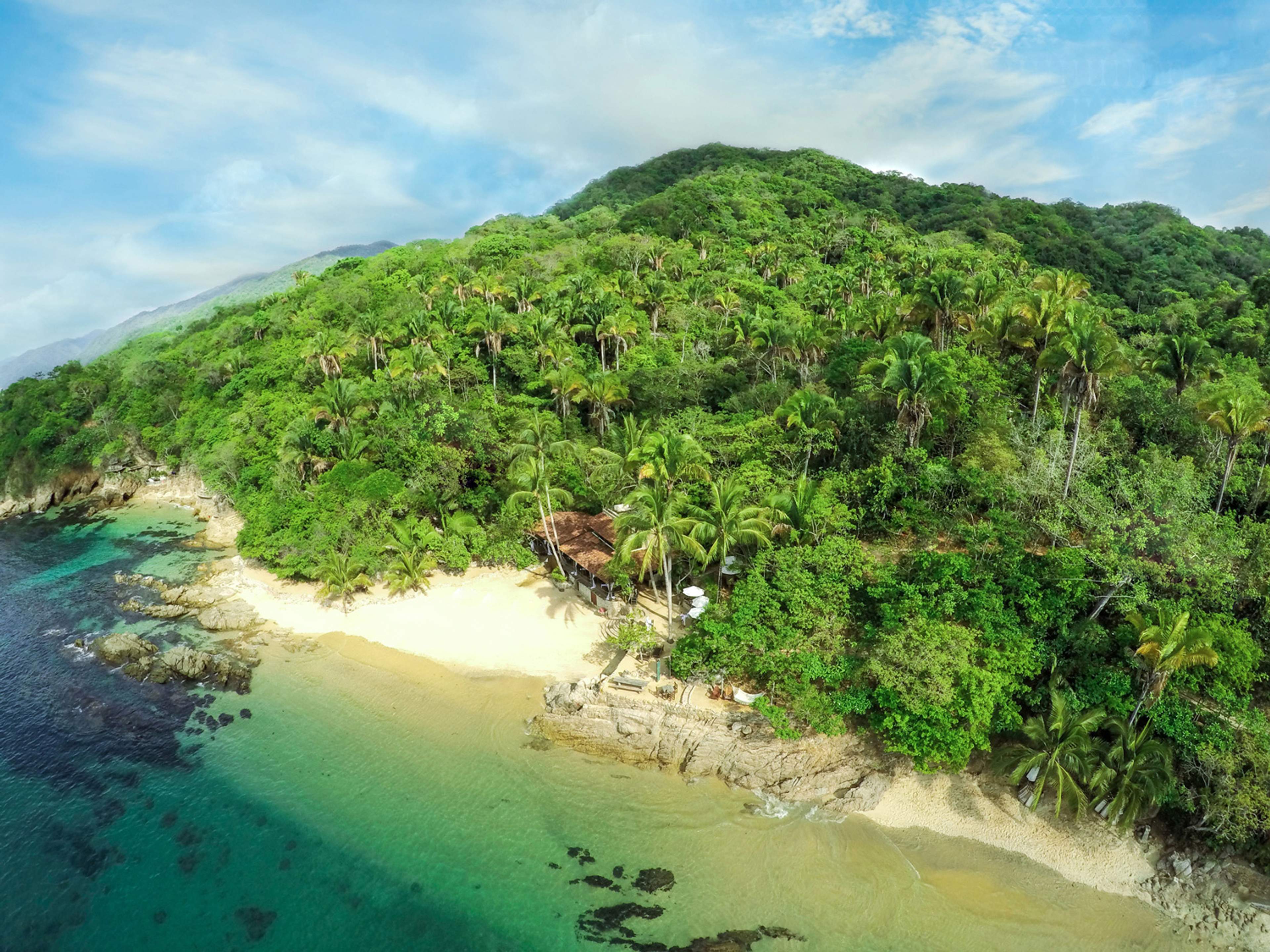 Aerial view of Las Caletas, a secluded beach with lush greenery and turquoise waters in Puerto Vallarta, Mexico.