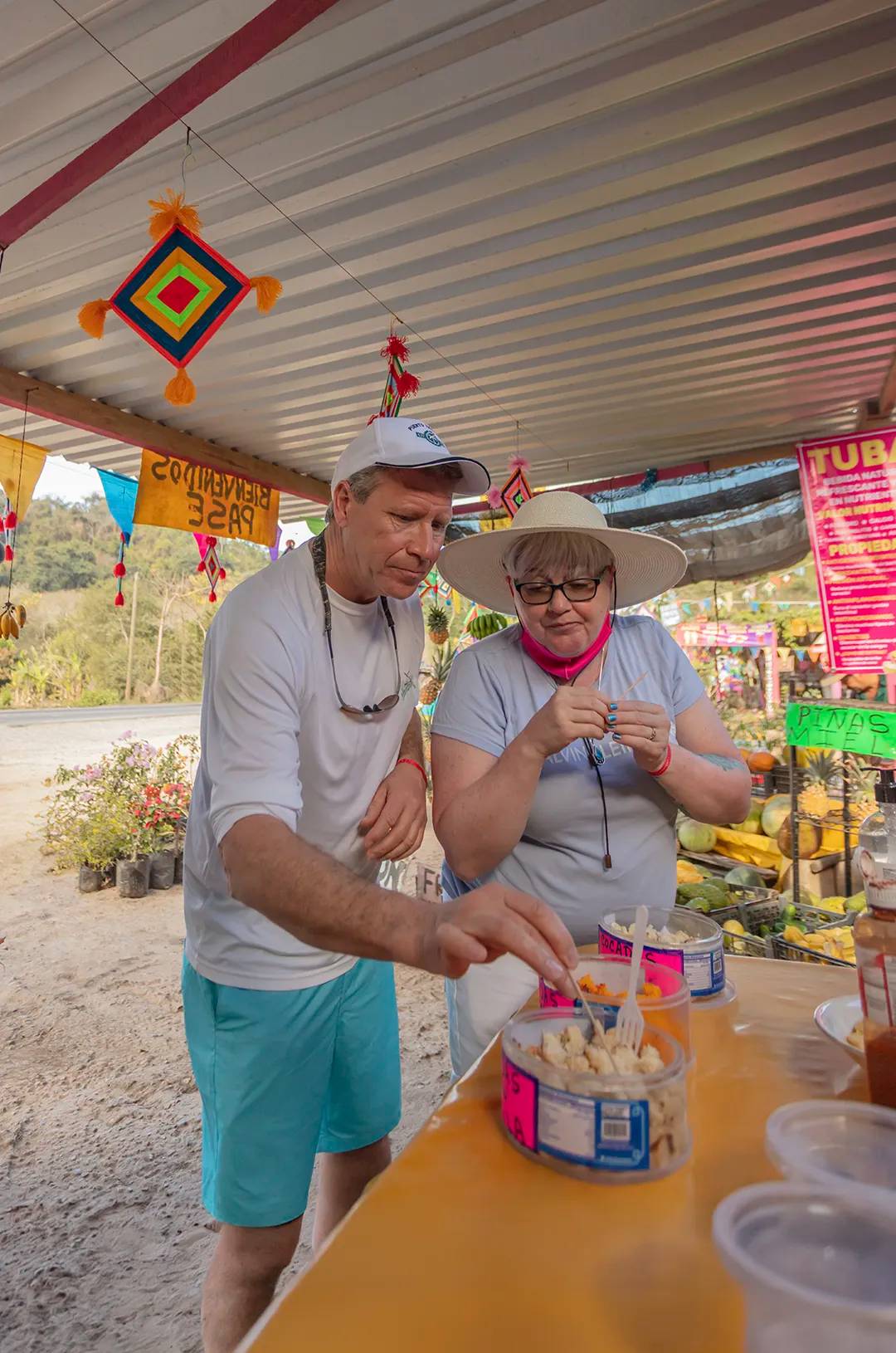 A couple tasting exotic fruits at a roadside stand in Sayulita, Mexico.
