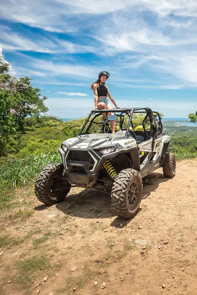 Mujer en un ATV Polaris RZR en un mirador panorámico con vista al océano cerca de Sayulita, México.