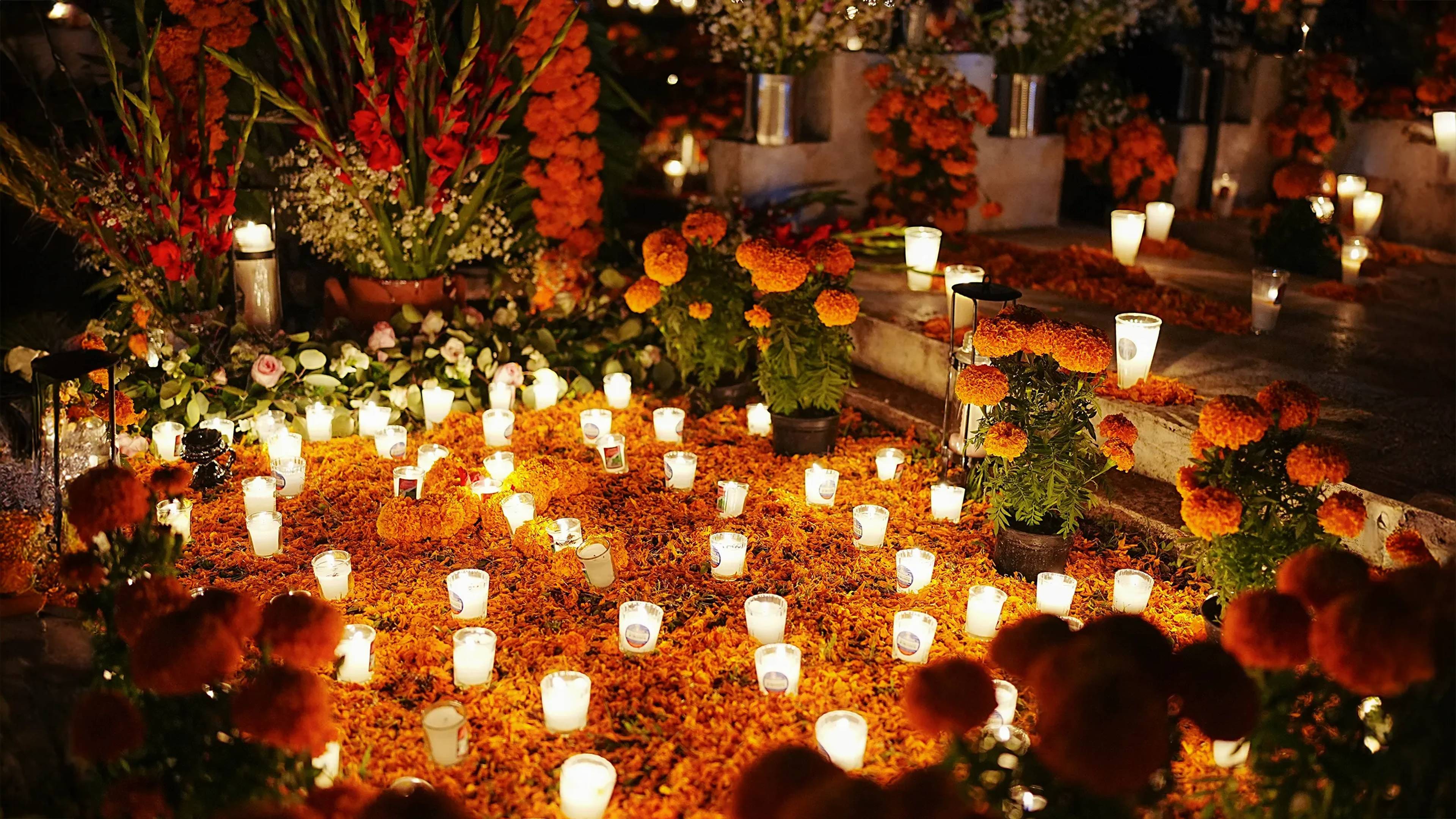 Day of the Dead celebration with marigold flowers and candles illuminating the night.