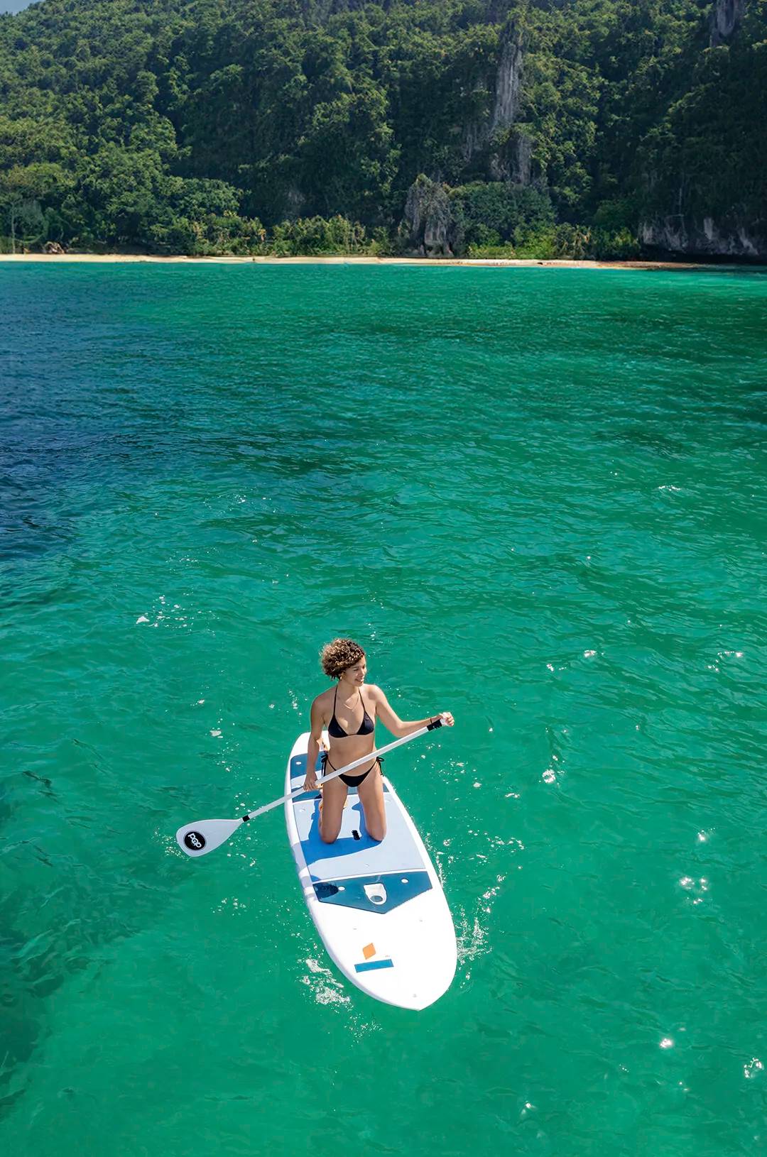 Woman paddleboarding in clear waters near the south shore of Puerto Vallarta.
