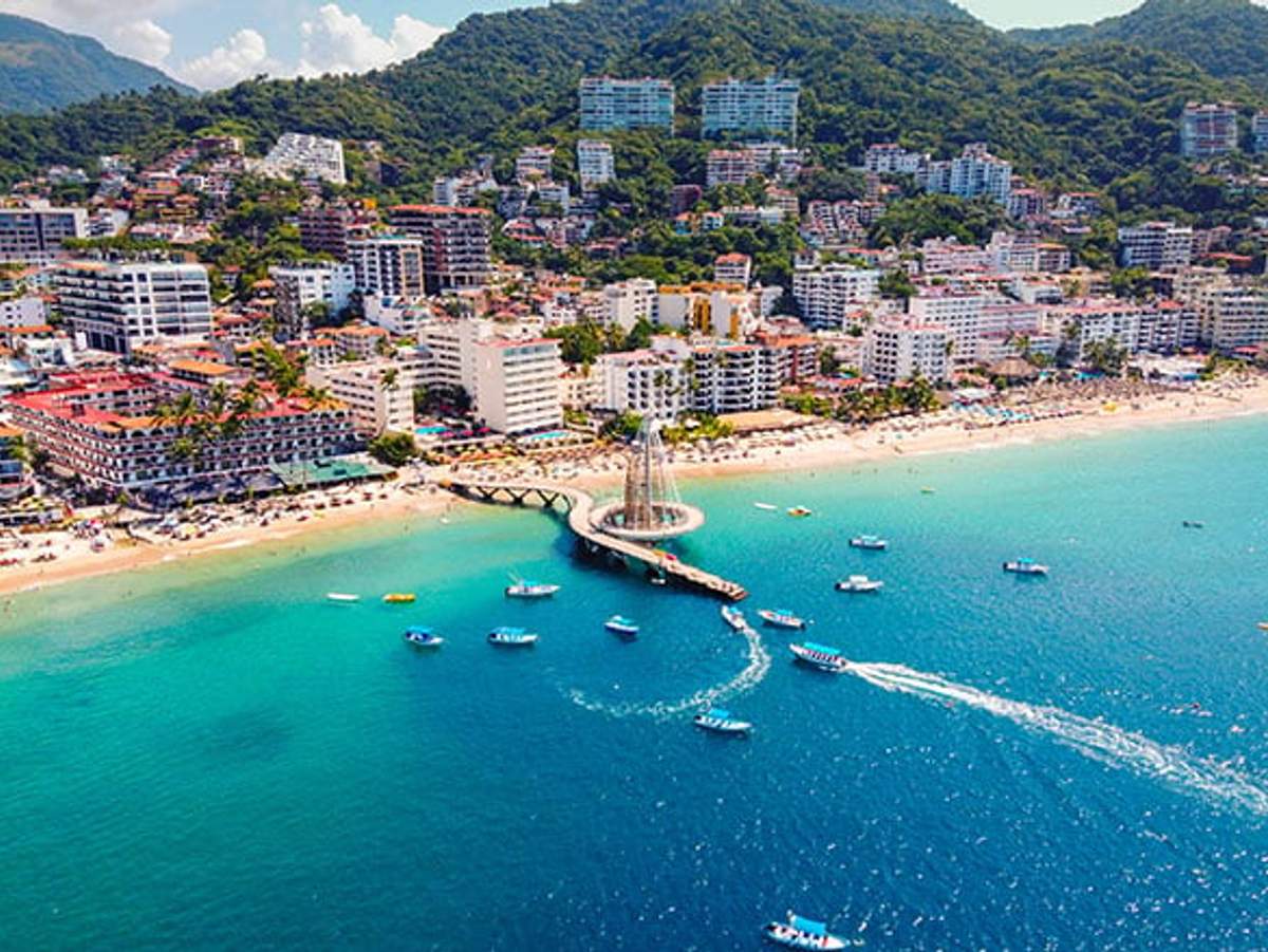 Aerial view of Zona Romantica in Puerto Vallarta with beach, pier, and boats.