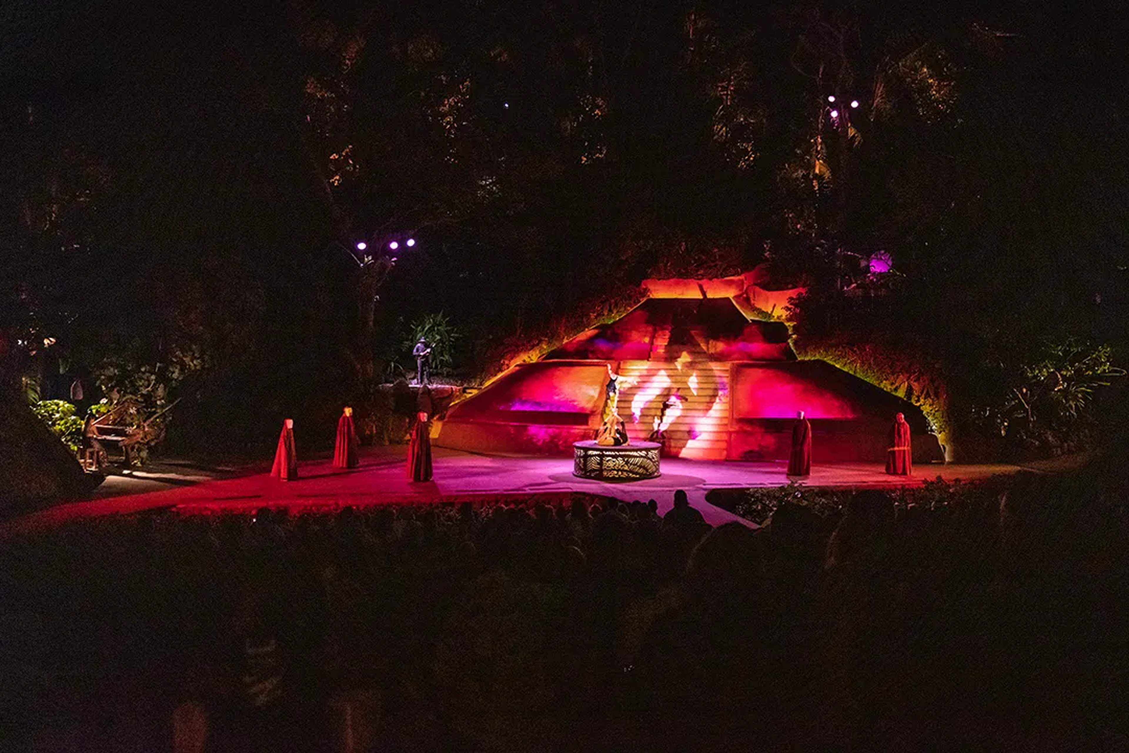 Mystical stage performance with fire and lights against a jungle backdrop at night, at ALMA by Rhytyhms of the Night.