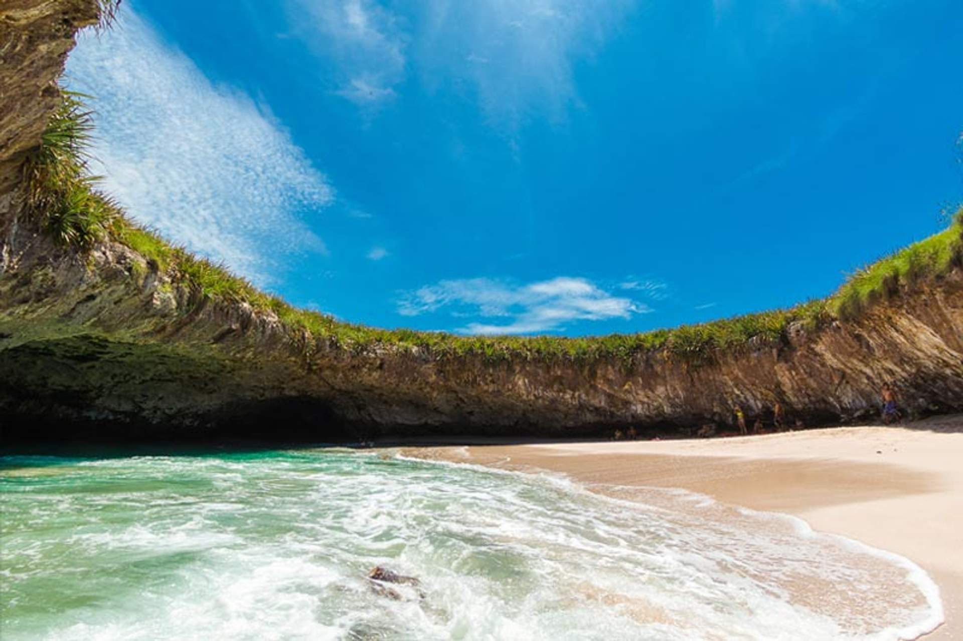 Hidden Beach with its turquoise waters and sandy shore, surrounded by lush greenery and an open sky in Marieta Islands, Mexico.