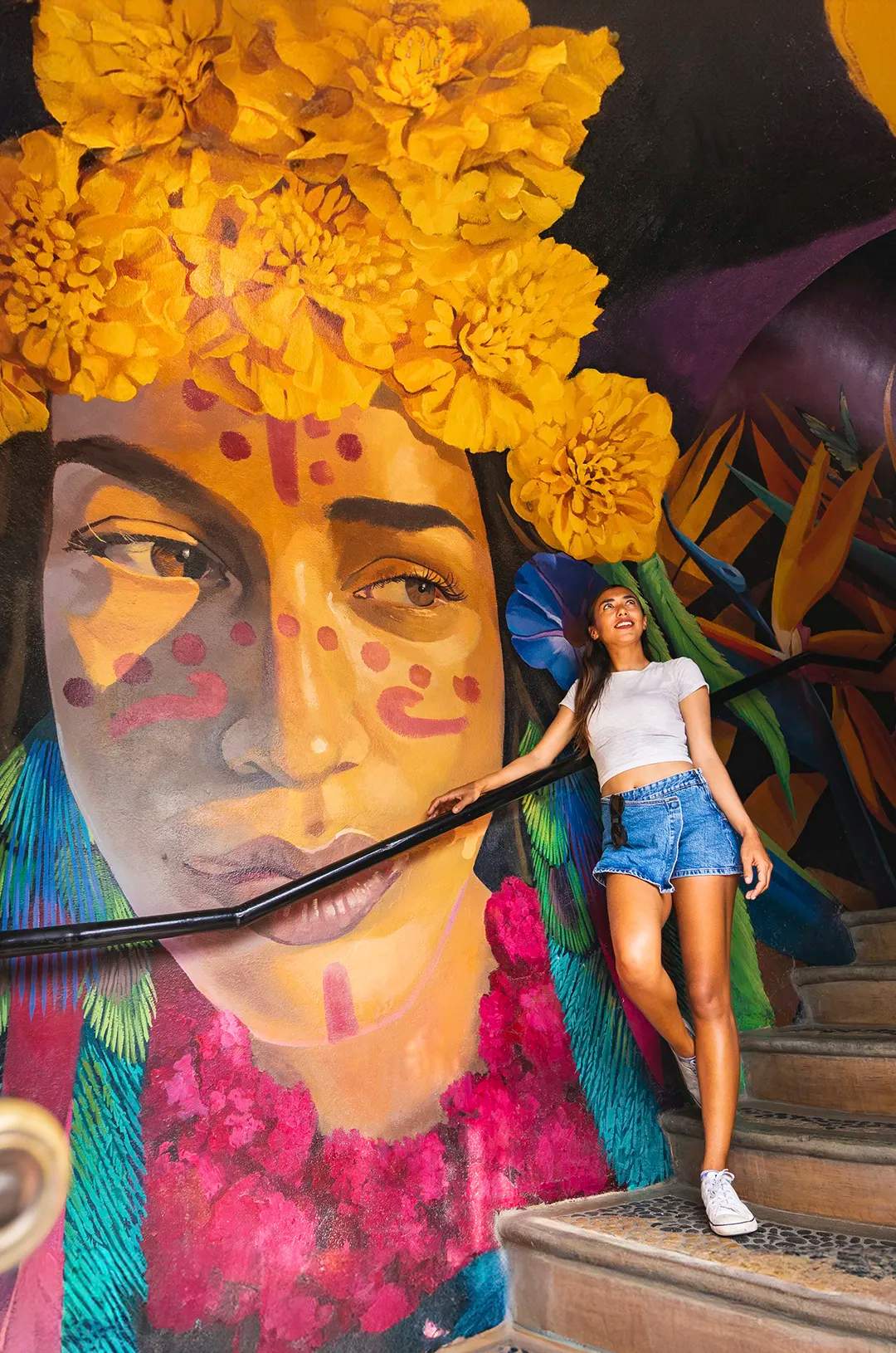 Woman posing in front of one of the beautiful Sayulita murals.