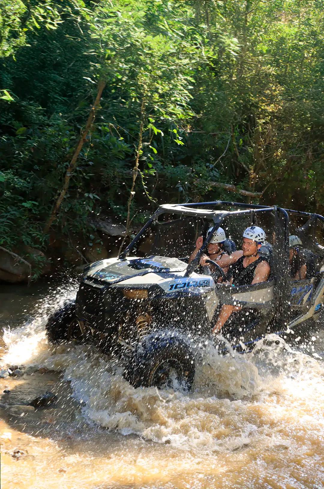 Aventureros atraviesan un arroyo en un ATV Polaris RZR en Puerto Vallarta en el tour de aventura Extreme Adventure.