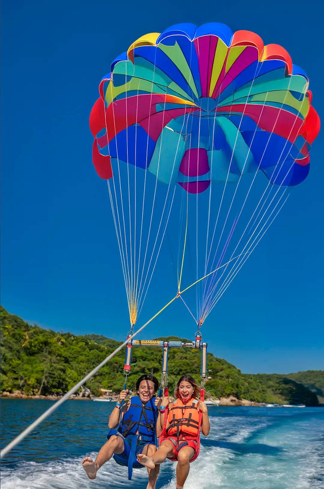 Amigos divirtiéndose en un parasailing en Puerto Vallarta.