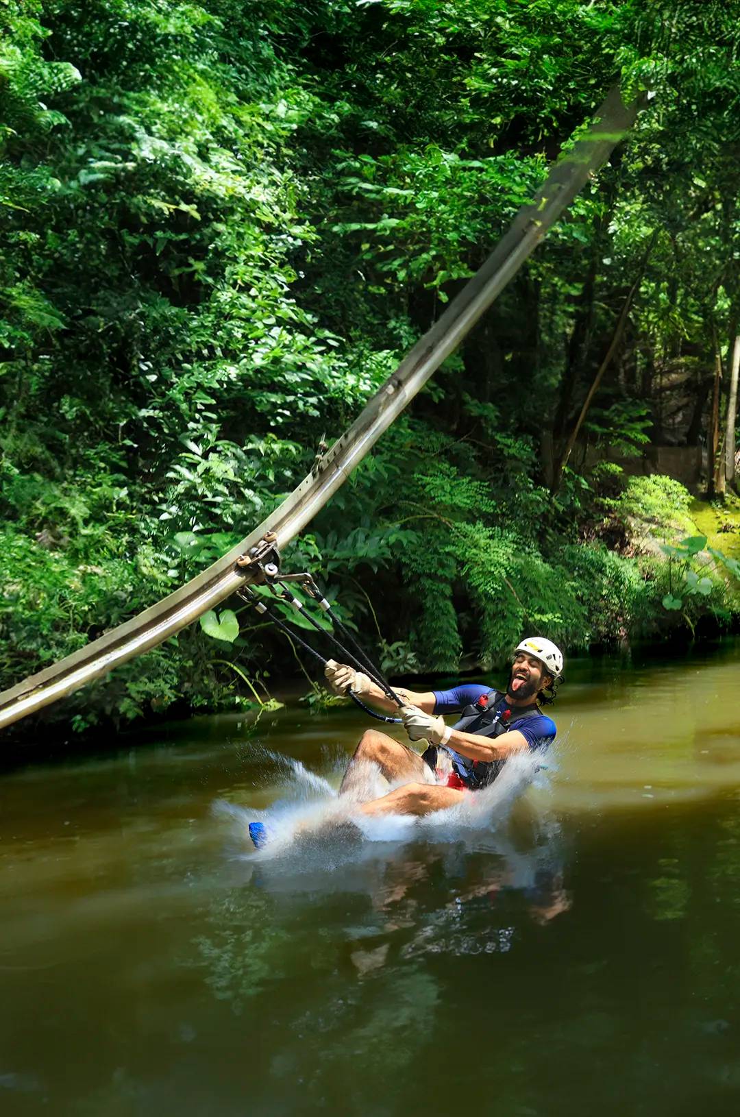 A person rides a zipline roller coaster over a river during an Outdoor Adventure in Puerto Vallarta.