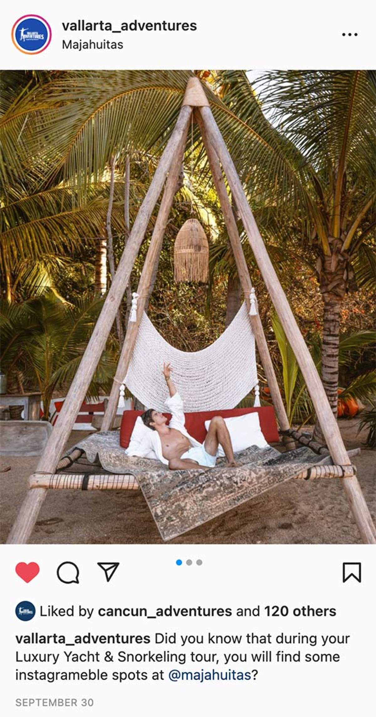 Man relaxing on a hammock under a wooden canopy, surrounded by palm trees at Majahuitas beach.