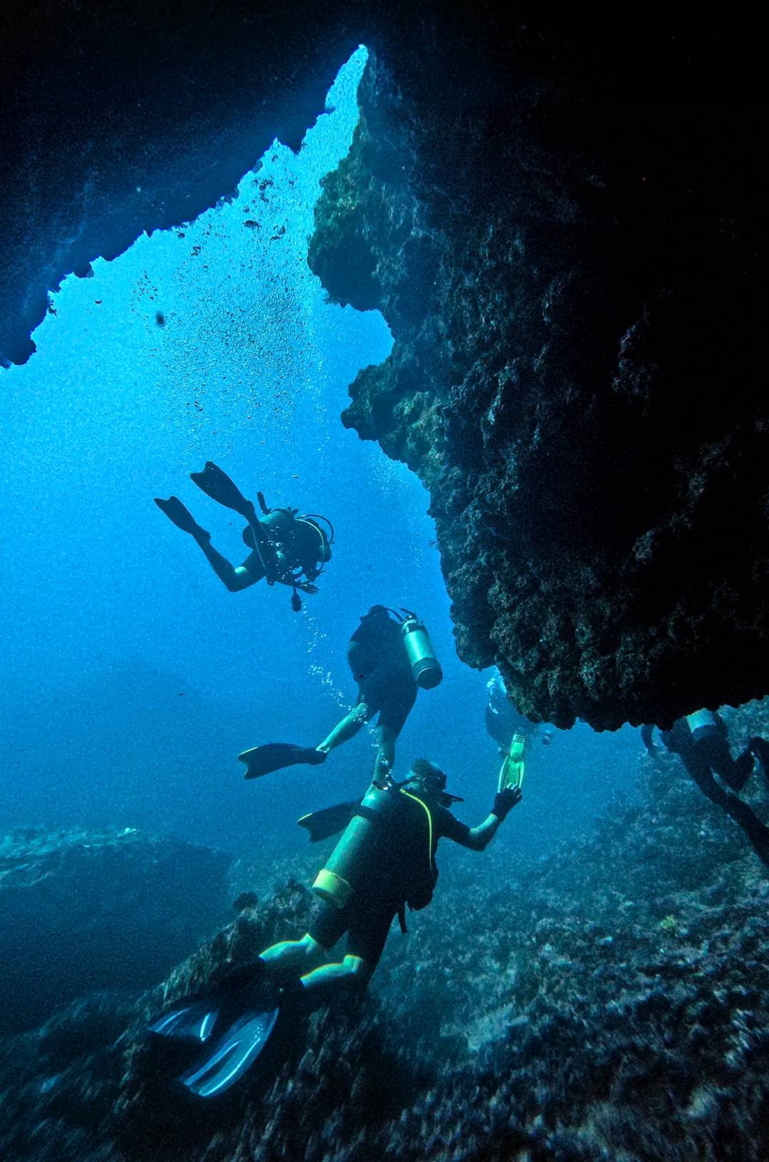Divers going through a underwater cave at El Morro Puerto Vallarta.