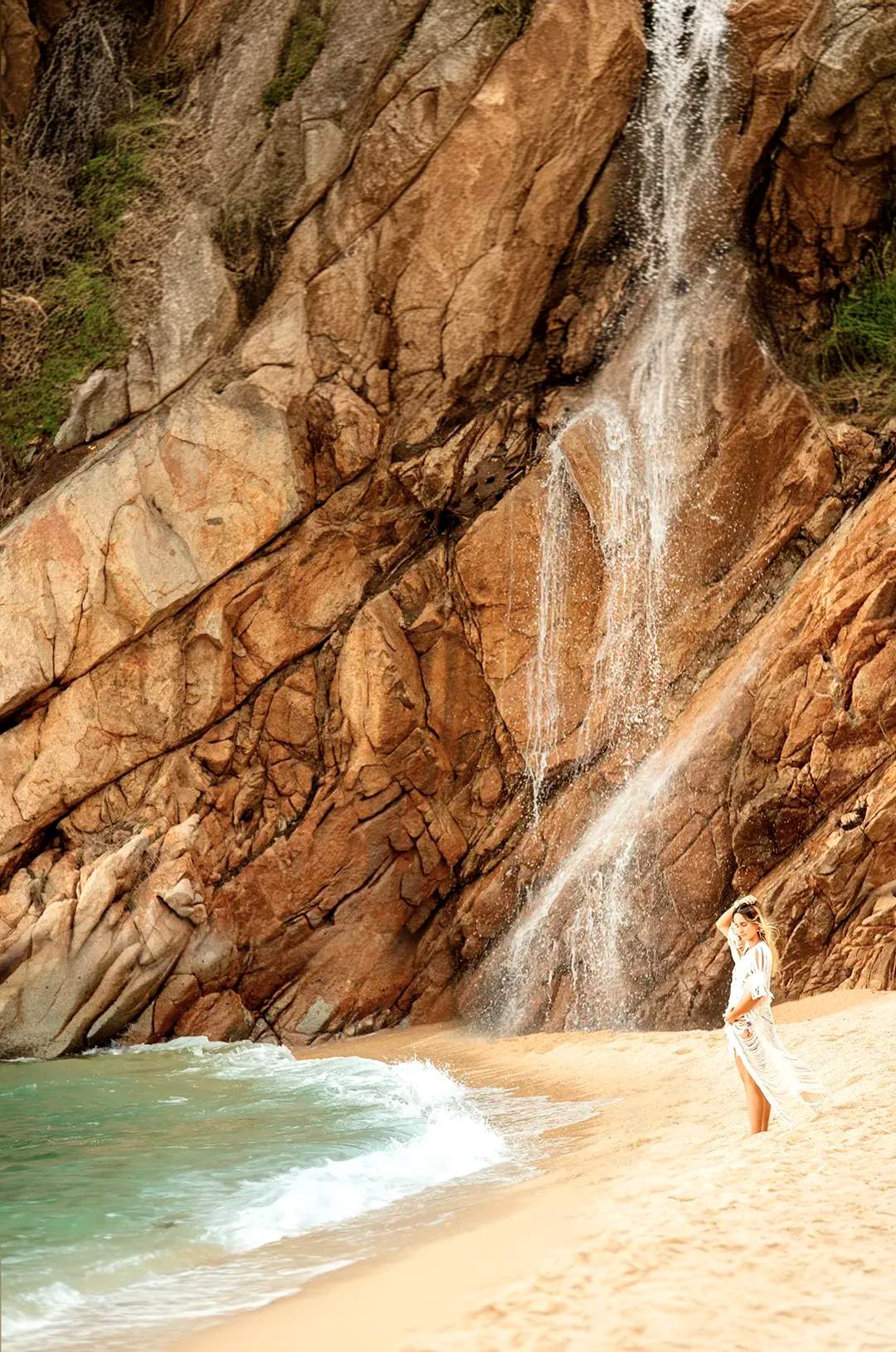 Mujer en la playa Majahuitas junto a una de las más hermosas cascadas en Puerto Vallarta.