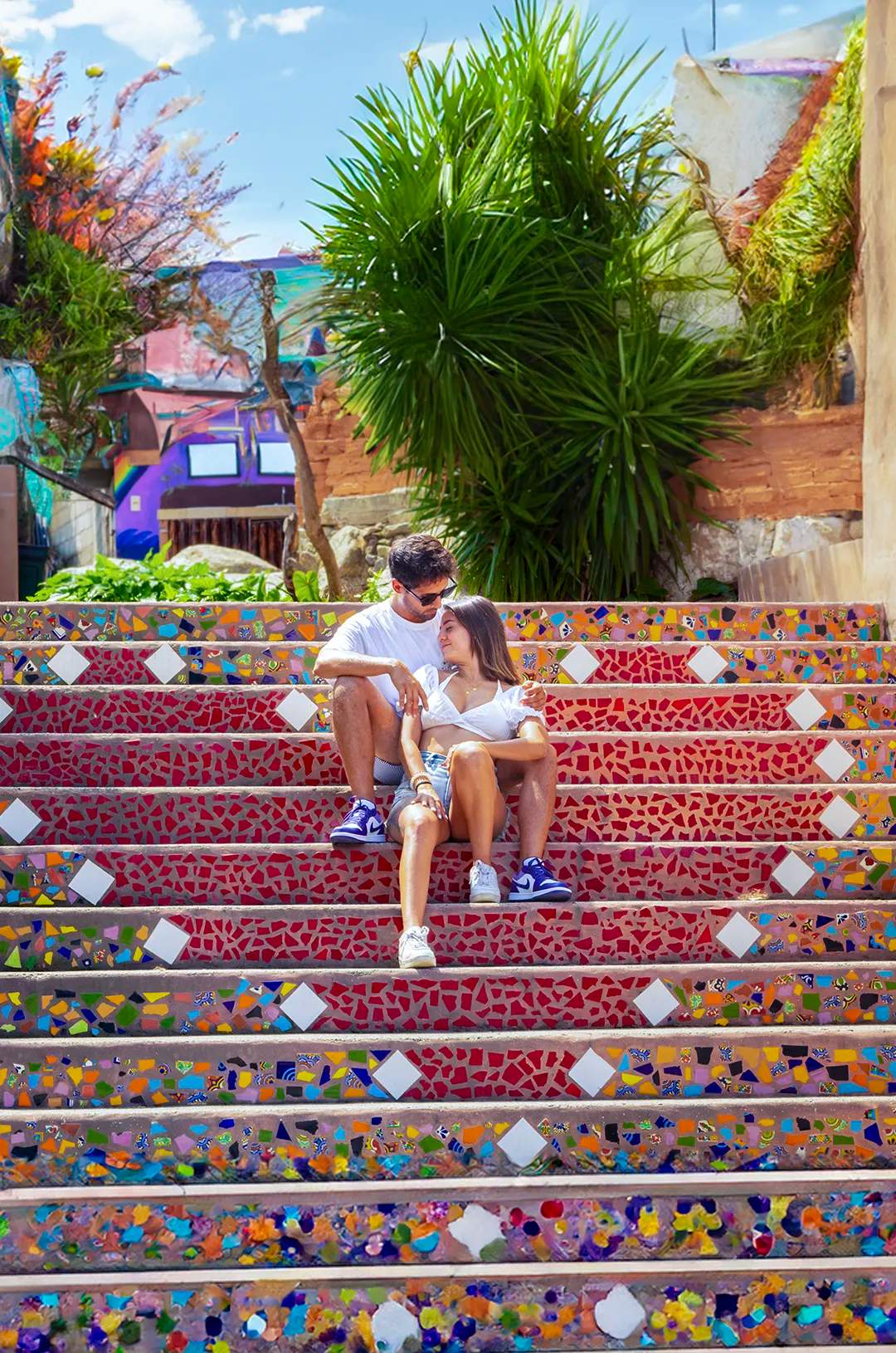 Woman sitting on a vibrant mosaic stairway in Yelapa, Mexico.