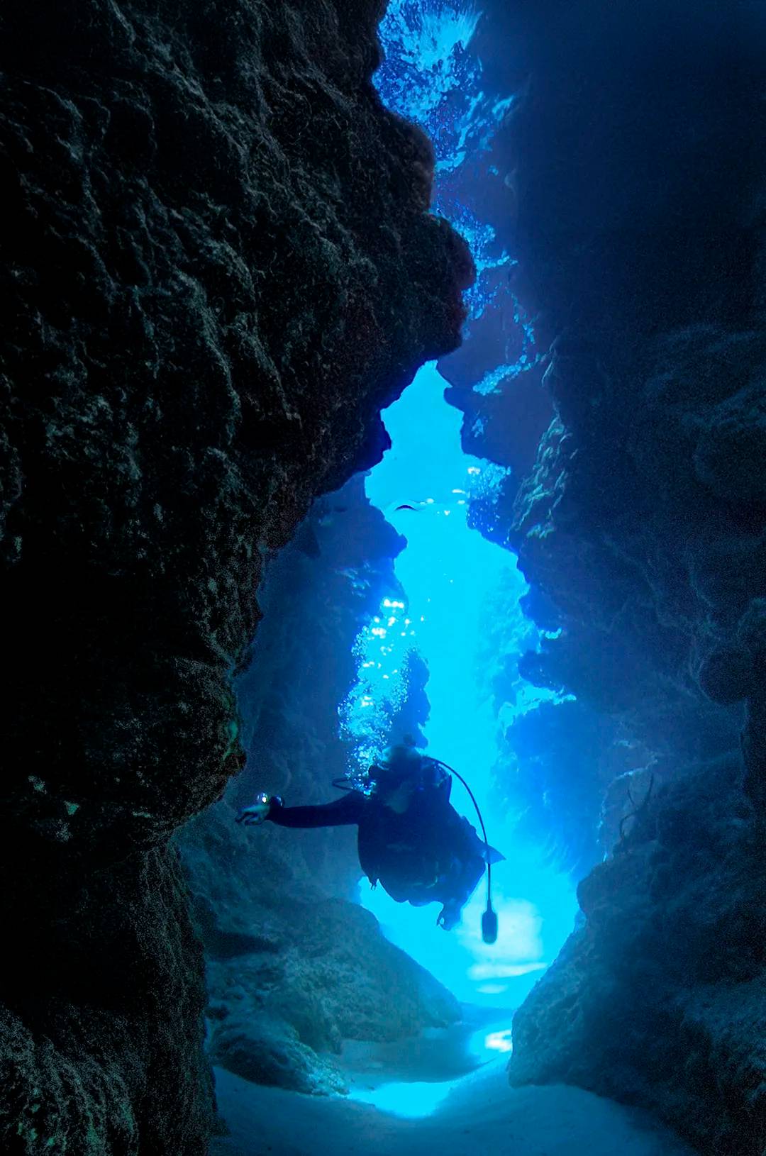 Diver going through an underwater tunnel beneath El Morro Puerto Vallarta.