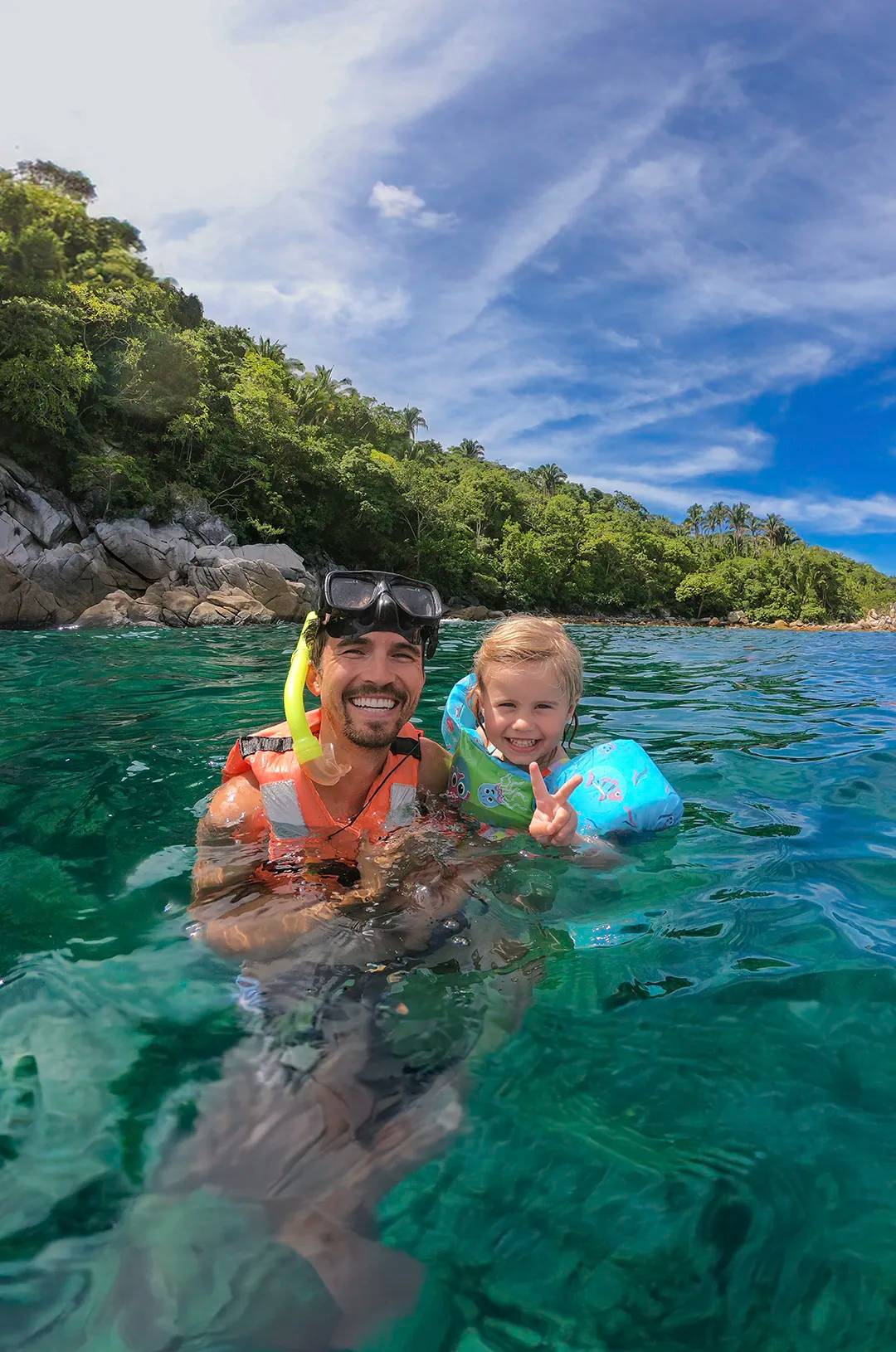 Family snorkeling in the warm, clear waters of Las Caletas beach in Puerto Vallarta.