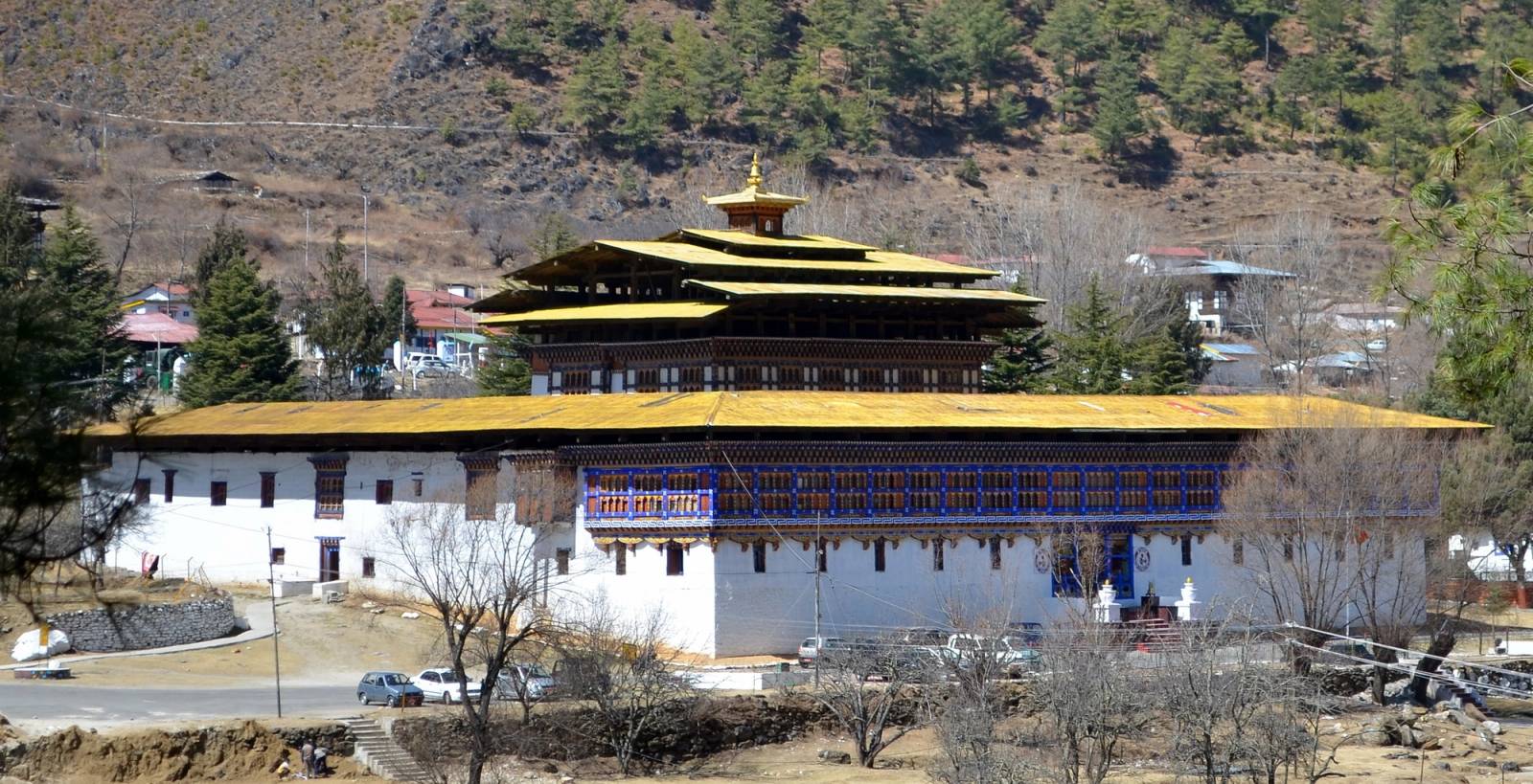 Wangchuk Lo Dzong in Haa, its golden-roofed central tower above whitewashed walls, pine hills behind