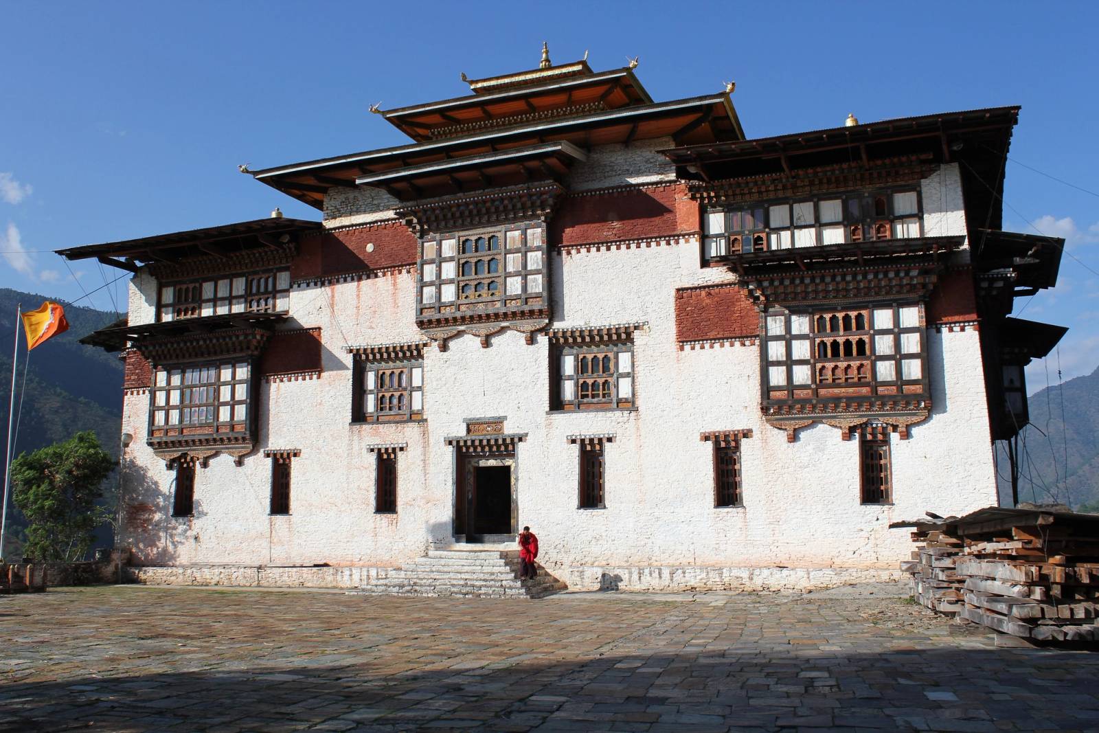 The whitewashed central tower of Trashigang Dzong with carved wooden windows, seen across its stone courtyard