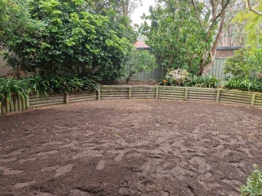 A bare, freshly prepared backyard of soil before a new lawn was laid