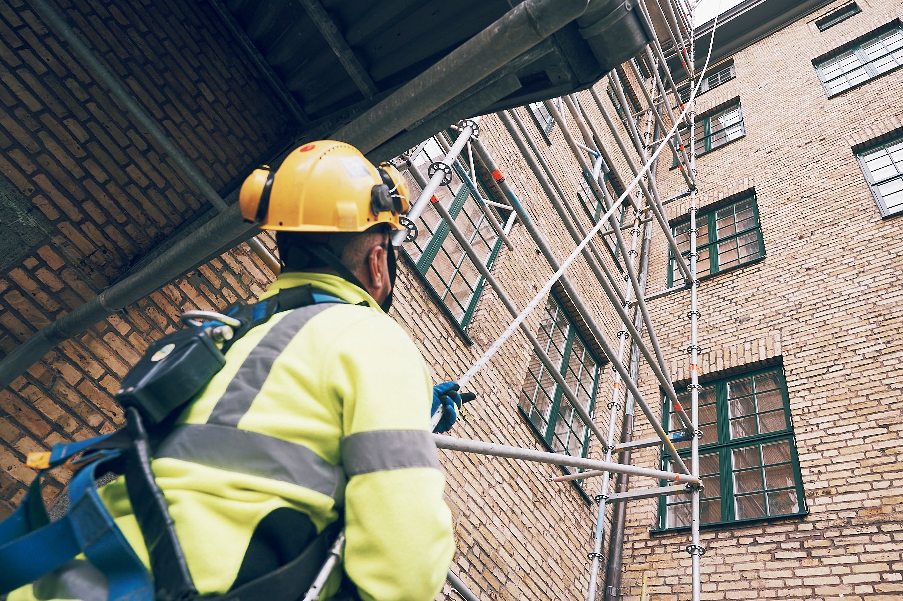 Person med säkring vid ställningsarbete