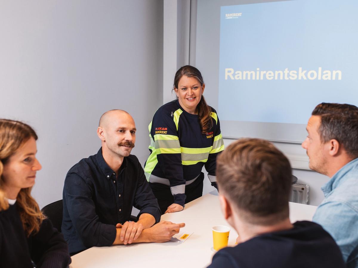 Ramirentskolan: Instruktör i varselkläder leder en lärarledd kurs i säkerhet med kursdeltagare i klassrum. Ta del av Ramirents utbildningar.