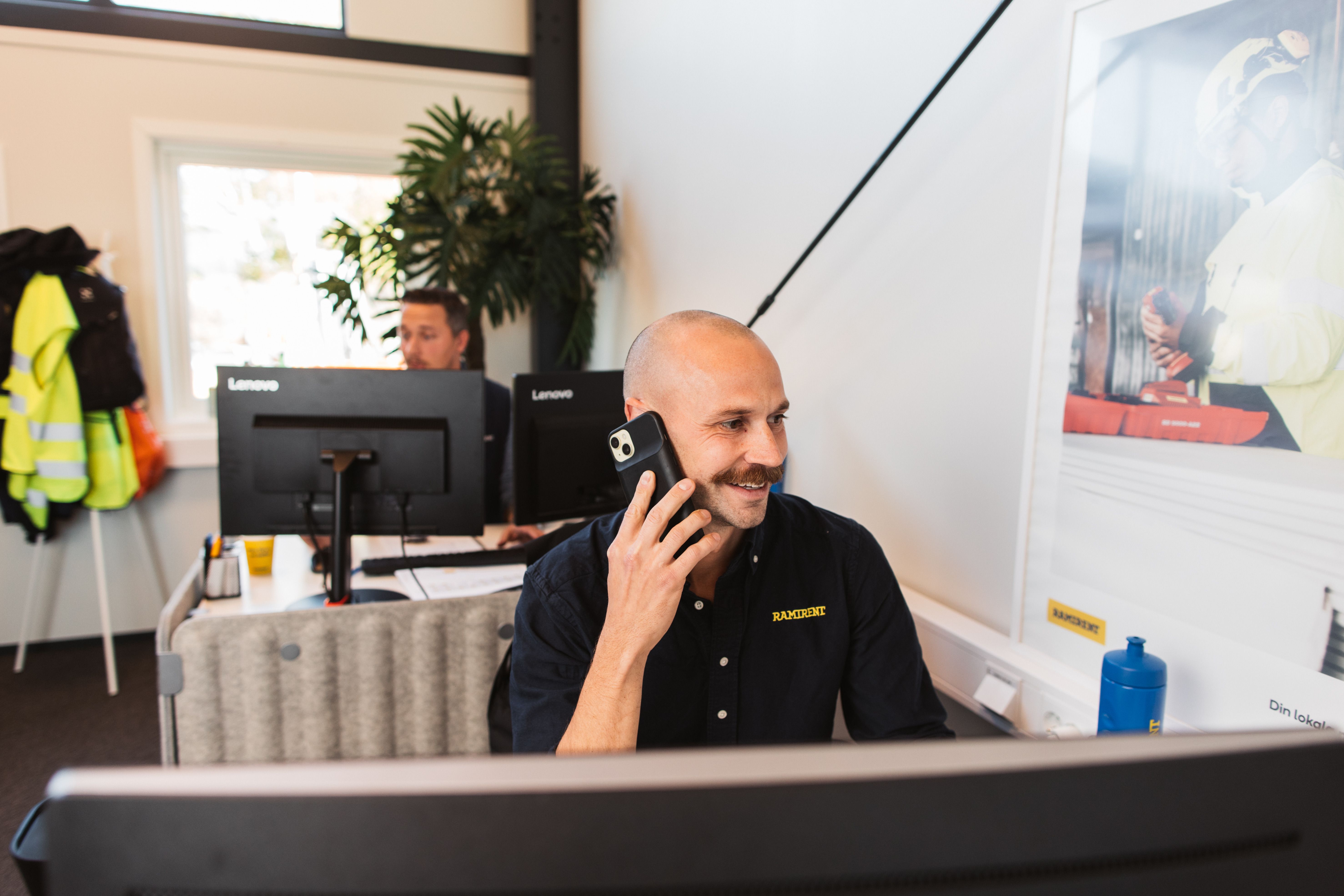 Två personer i varselväst tittar på surfplatta