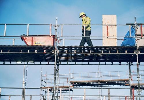 En yrkesarbetare på en byggställning som symboliserar Ramirents arbete för en hållbar byggbransch genom säkerhet, cirkulära lösningar och effektiv resursanvändning.
