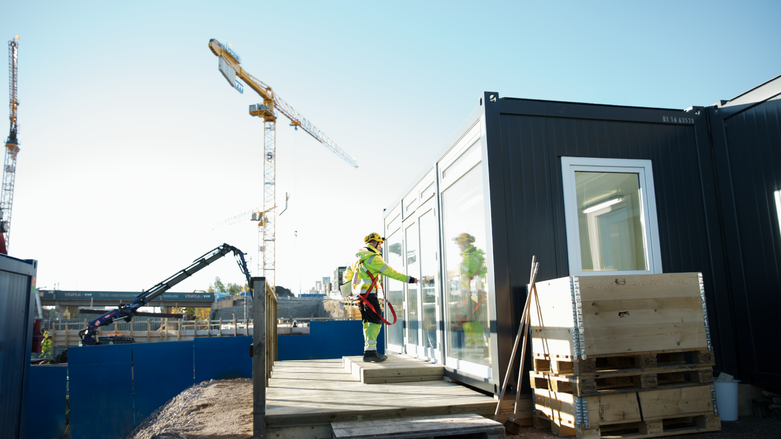 Byggarbetare vid Ramirents svarta bodar och modulsystem. Illustrerar våra helhetslösningar och tjänsteerbjudanden.