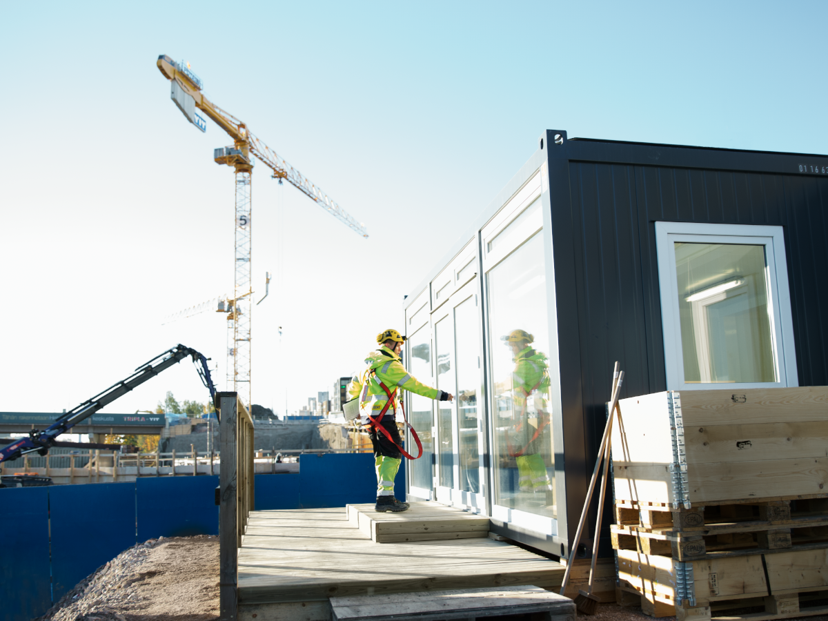 Byggarbetare vid Ramirents svarta bodar och modulsystem. Illustrerar våra helhetslösningar och tjänsteerbjudanden.