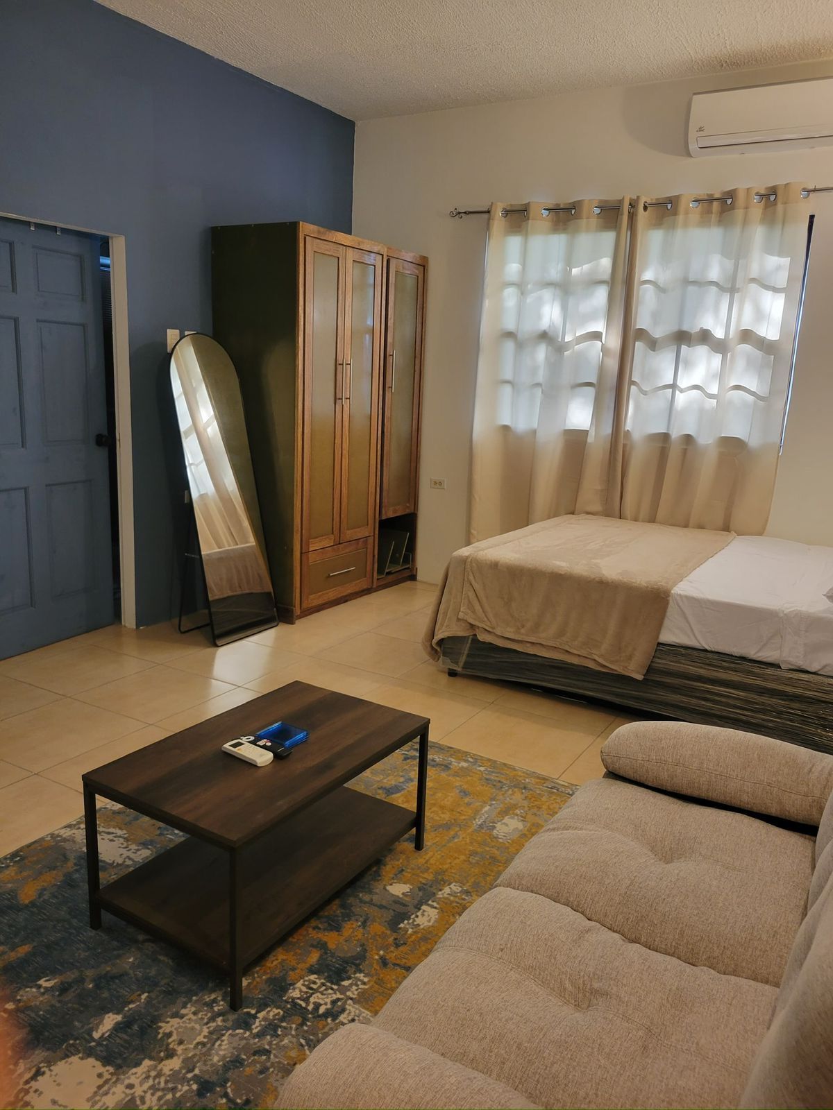 Bedroom with a double bed, wooden wardrobe and full-length mirror