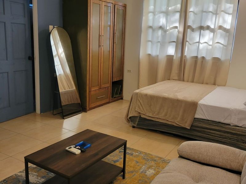 Bedroom with a double bed, wooden wardrobe and full-length mirror