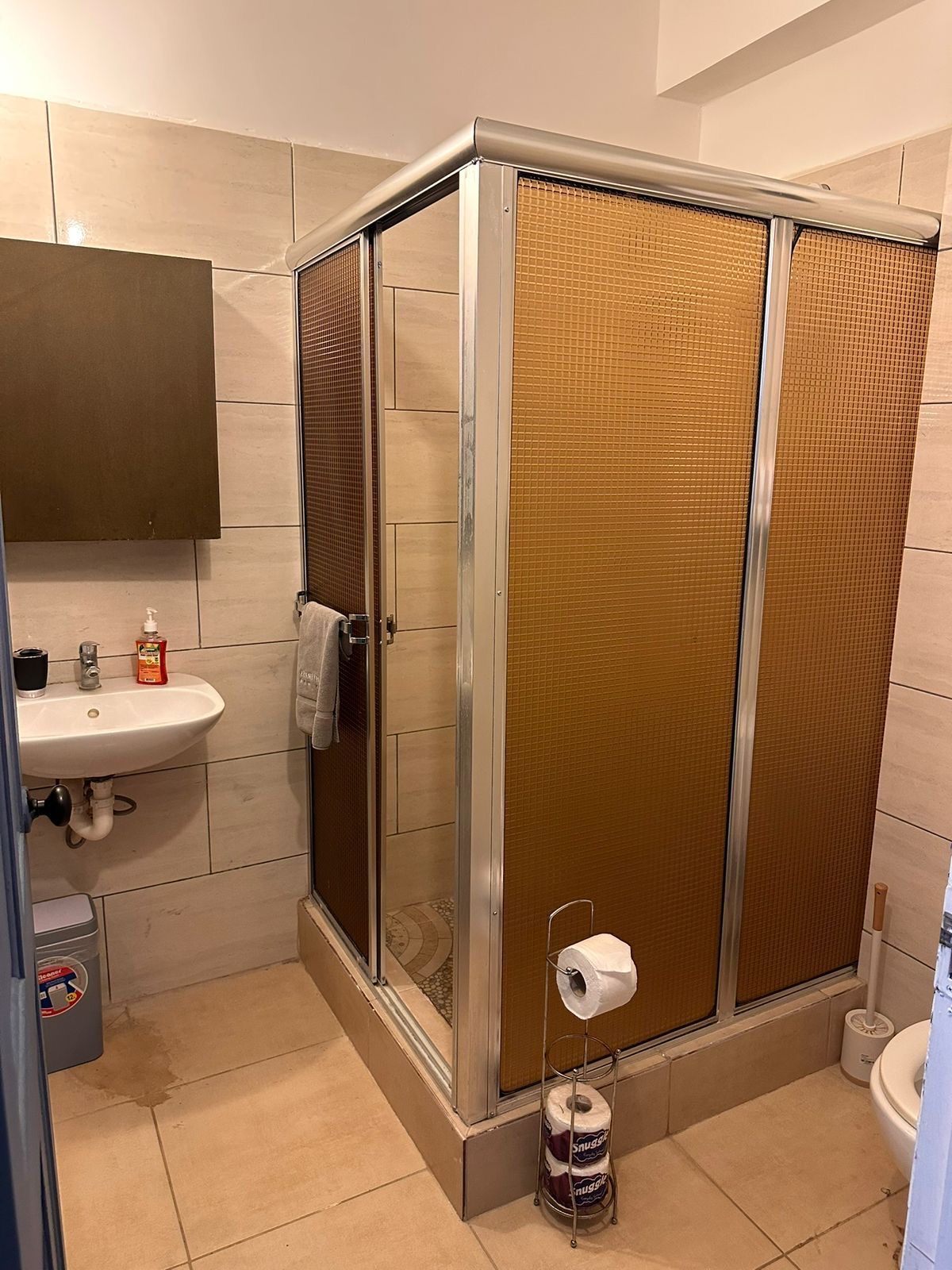 Bathroom with a corner shower cubicle and wash basin