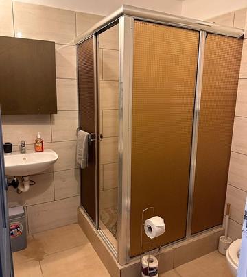 Bathroom with a corner shower cubicle and wash basin