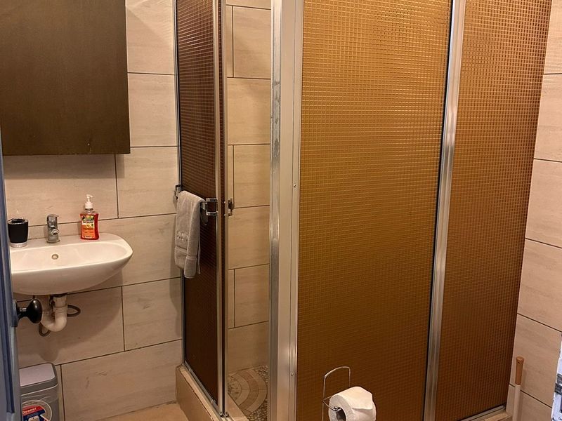 Bathroom with a corner shower cubicle and wash basin