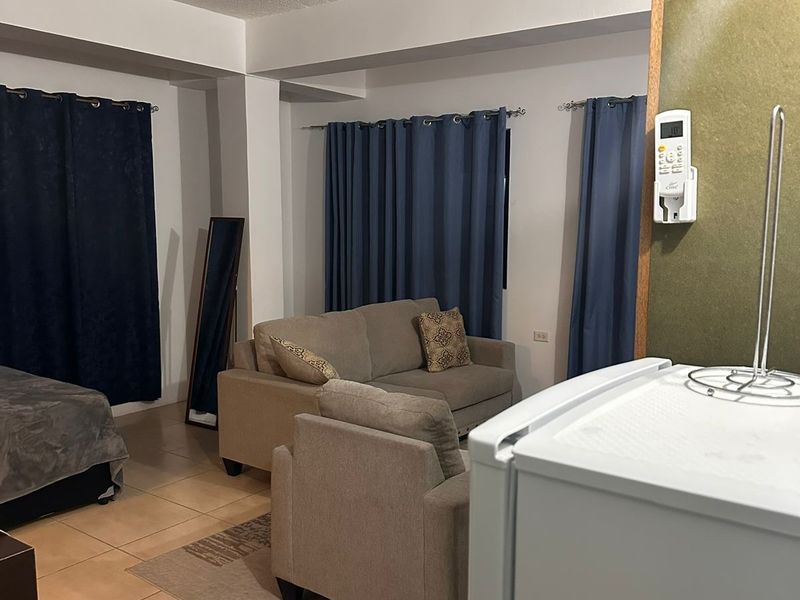 Studio room with a double bed, two-seat sofa and armchair