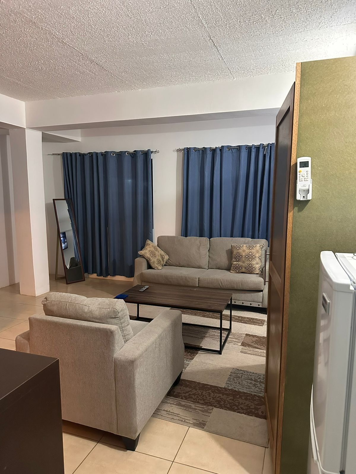 Seating area with two sofas, a coffee table and navy curtains