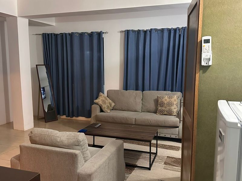 Seating area with two sofas, a coffee table and navy curtains