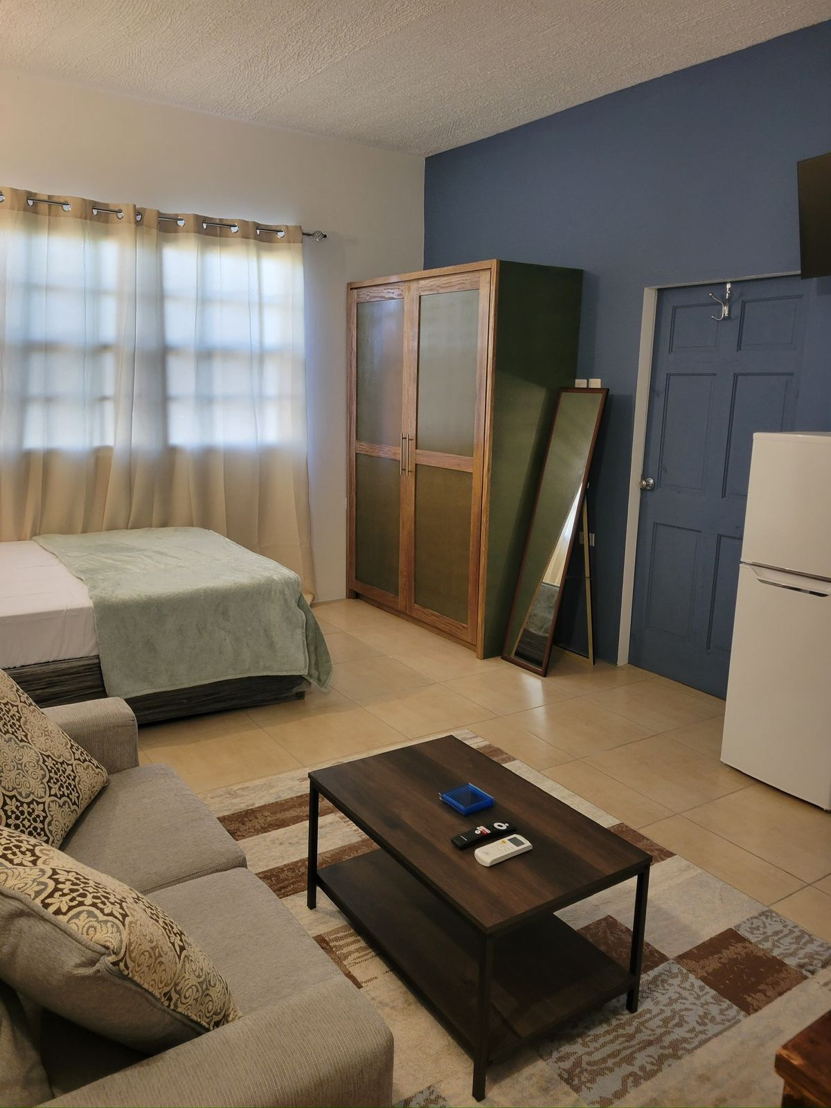 Studio room with a double bed, wardrobe, fridge and sofa