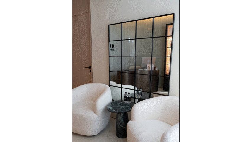 Finished lounge with seating and black-framed mirror