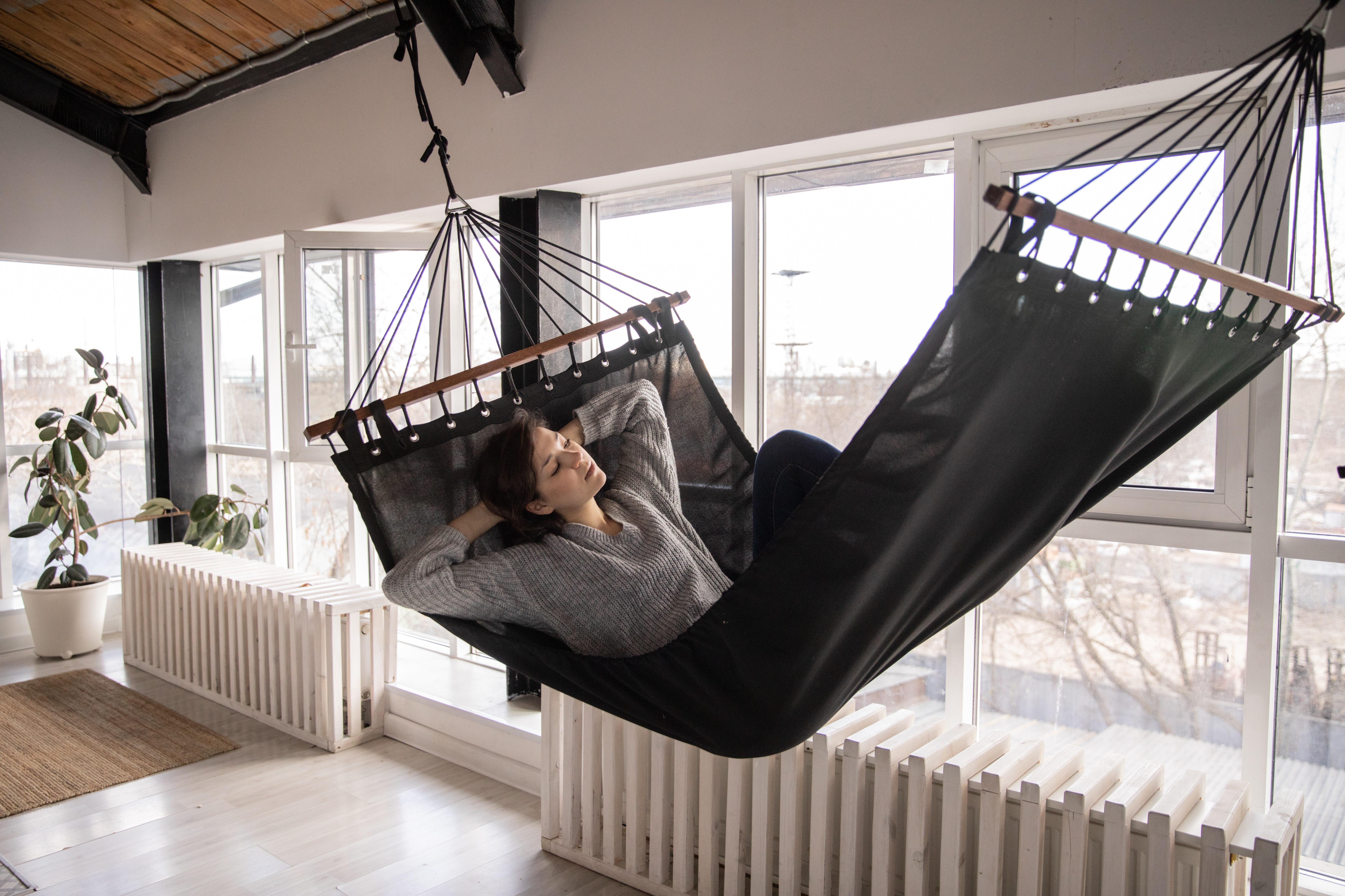 Frau in Hängematte vor Fensterfront