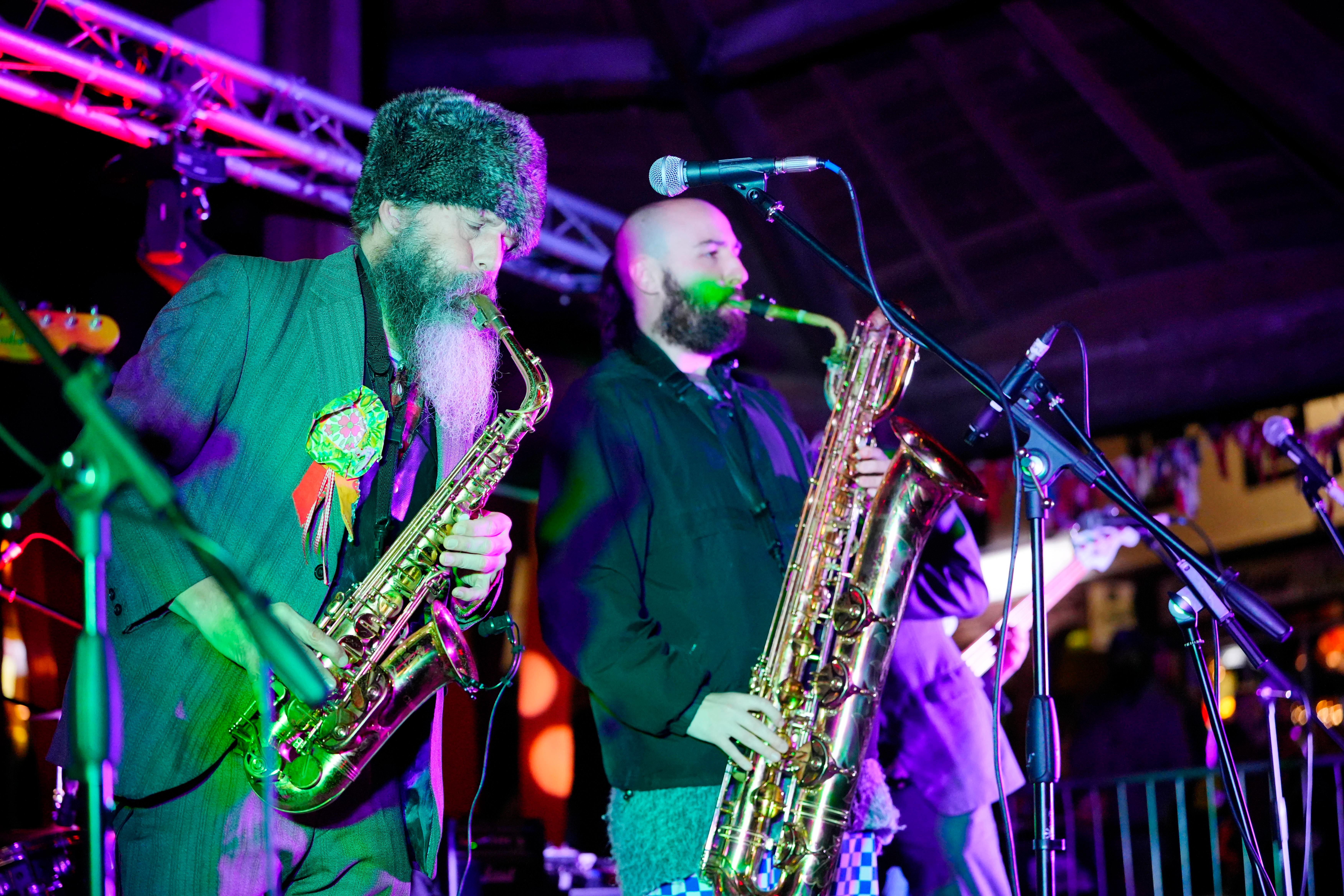 Two band members on stage with saxophones