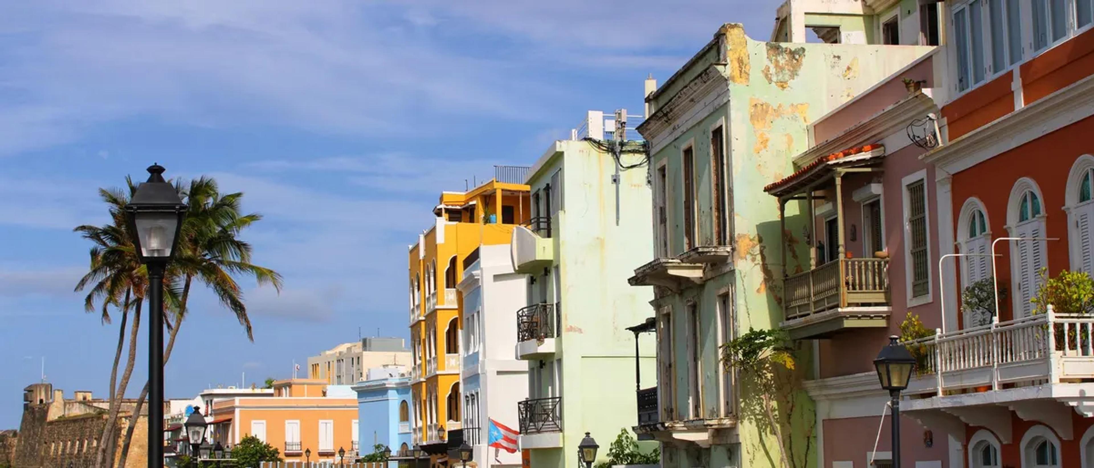 Colorful colonial buildings and a Puerto Rican flag along a sunny street in Old San Juan