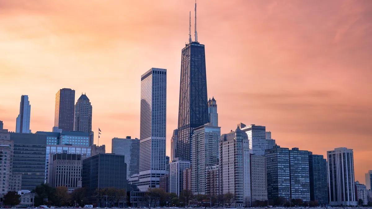 The Chicago skyline along Lake Michigan at sunset, with the John Hancock Center at center