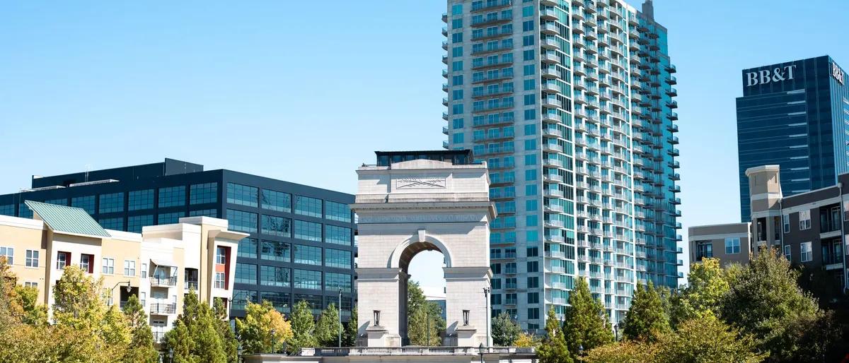 The Millennium Gate arch and high-rise towers at Atlantic Station, Atlanta, under a blue sky