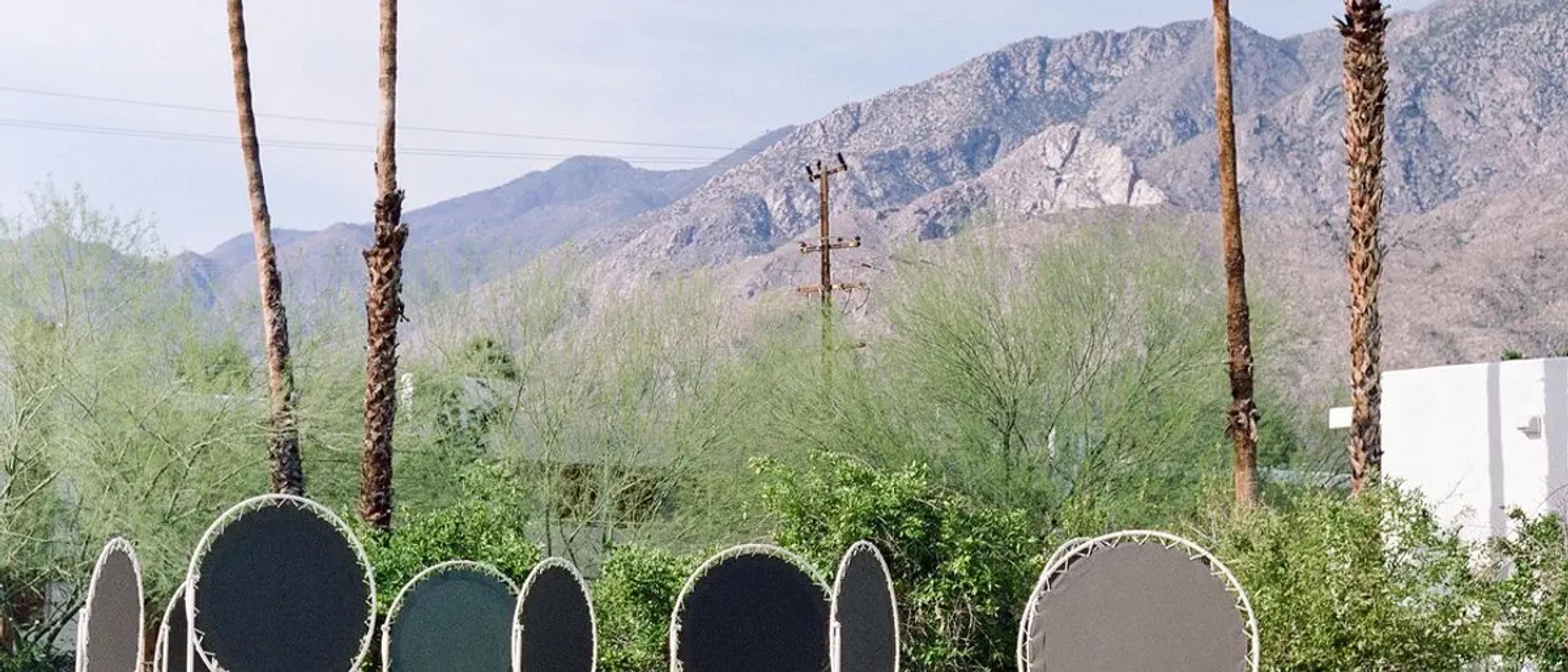 Resort pool with lounge chairs and the San Jacinto mountains behind it in Palm Springs
