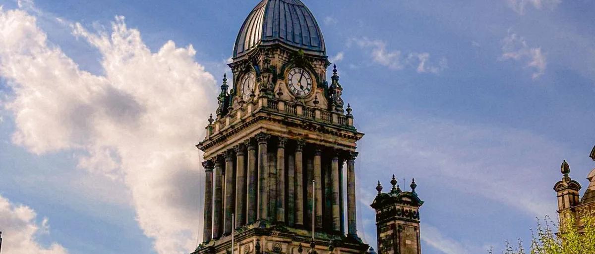 The clock tower of Leeds Town Hall against a blue sky